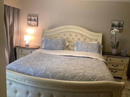 a bedroom with a large bed with blue sheets and pillows at Cozy nest in Coquitlam