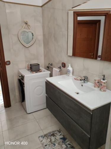 a bathroom with a sink and a washing machine at CasaMare Luxury Siderno in Siderno Marina