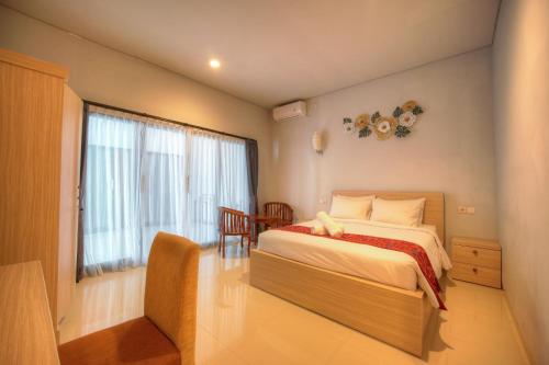 a bedroom with a large bed and a window at The Joy Rooms Penida in Nusa Penida