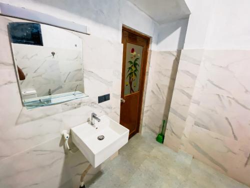 a white bathroom with a sink and a mirror at Senaro Villa in Sigiriya