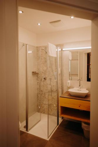 a bathroom with a glass shower and a sink at Hotel Post Hönigwirt in Kirchschlag