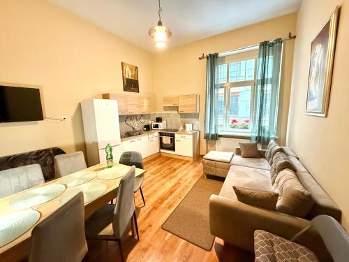 a living room with a dining table and a kitchen at Oasis Valley Karlovy Vary Center in Karlovy Vary