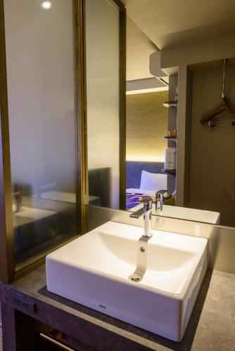 a white sink in a bathroom with a mirror at Kyoto Travellers Inn in Kyoto