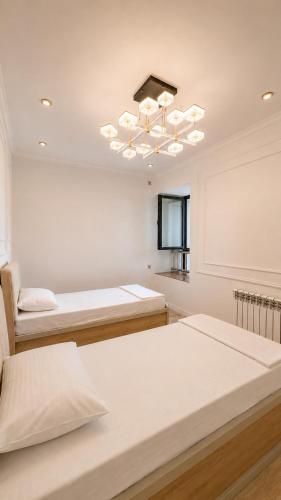 a room with two beds and a chandelier at High Town City in Lunacharskiy Bekati