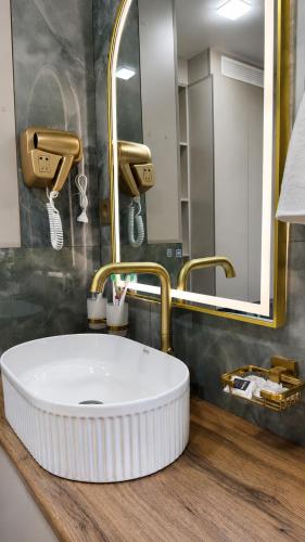 a bathroom with a white sink and a mirror at High Town City in Lunacharskiy Bekati