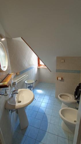 a bathroom with two sinks and two toilets at LA ROCCA BIANCA in Demonte