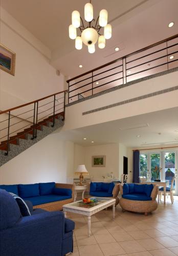 a living room with blue couches and a staircase at Papago International Resort in Chishang