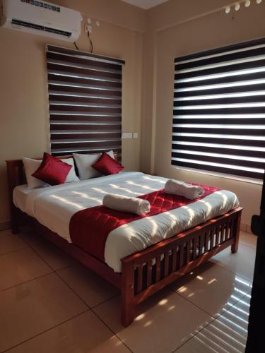 a bedroom with a large bed with red pillows at Dreams Arcade in Nedumbassery