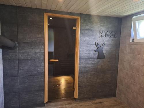 a bathroom with a door with a deer head on the wall at Tuule in Jeedasküla