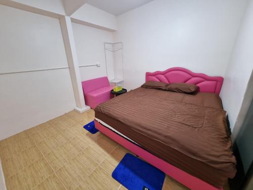 a bedroom with a large bed with a pink head board at Nopphadon Hotel in Lat Krabang