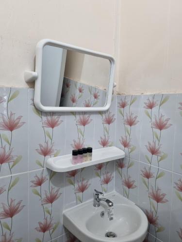 a bathroom with a sink and a mirror at Nopphadon Hotel in Lat Krabang