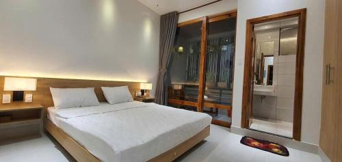 a bedroom with a large white bed and a window at Hotel Suối Cao in Phú Quốc