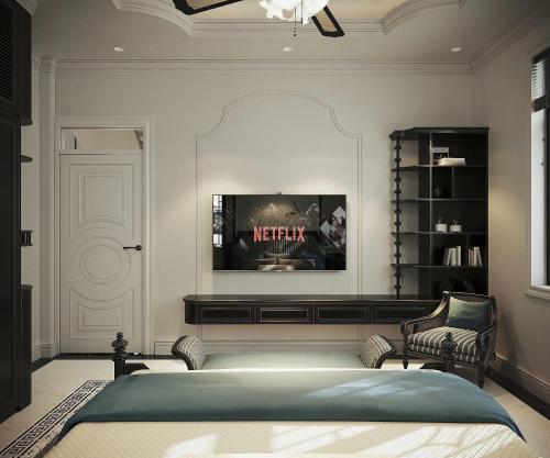 a bedroom with a bed and a tv on the wall at Grand KAS Premium Hotel & Sky Bar in Ho Chi Minh City