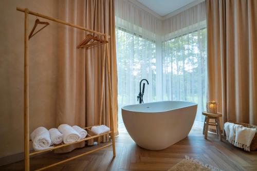 a bathroom with a tub and a large window at Dziupla House in Czarna