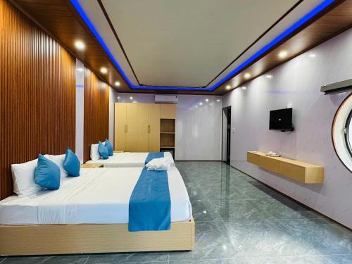 a bedroom with two beds and a tv on a wall at Hoi An Ocean Waves Homestay in Hà My Tây (2)