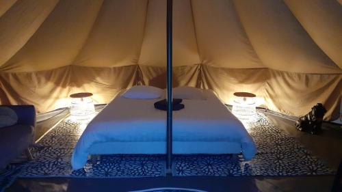a bedroom with a bed in a tent at Logement insolite tente glamping in Parigné-lʼÉvêque