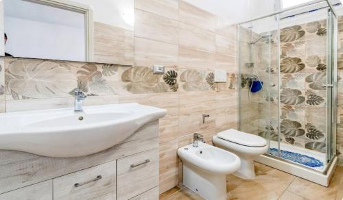 a bathroom with a sink and a toilet and a shower at Villa Blu Dea room & apartment in Torre Lapillo