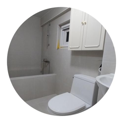 a bathroom with a toilet and a sink and a mirror at The upper room디어퍼룸 in Mahŭl-tong