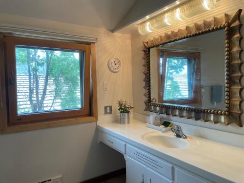 a bathroom with a sink and a mirror and a window at H on the bund in Saskatoon