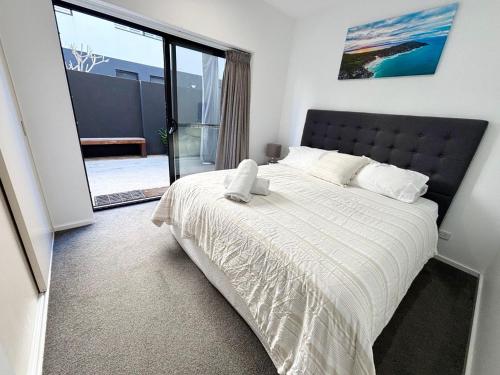 a bedroom with a large bed with a large window at Nineteen On Gregory G02 in South West Rocks