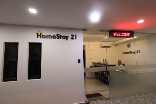 a man is sitting at a welcome sign in a building at HomeStay 21 Hotel in Johor Bahru
