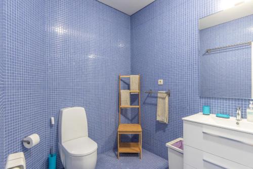 a blue tiled bathroom with a toilet and a sink at Beach Sunset - Apartment Ocean in Vila Nova de Gaia