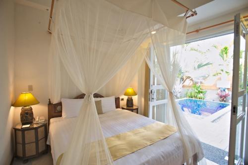 a bedroom with a bed with mosquito netting at Papago International Resort in Chishang