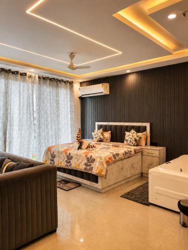 a bedroom with a bed and a couch at Elvora Stay's - Studio with Jacuzzi in Ghaziabad
