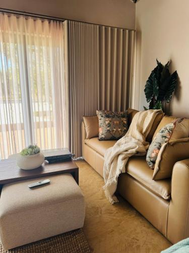 a living room with a couch and a table at Siki's Cactus Hideaway in Mmokolodi