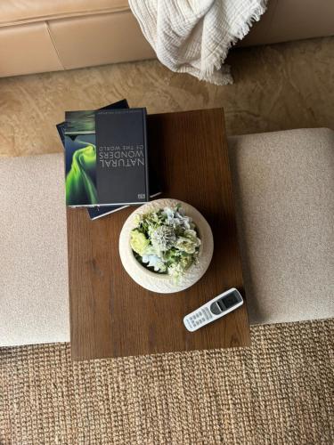 a table with a plate of food and a book and a remote control at Siki's Cactus Hideaway in Mmokolodi