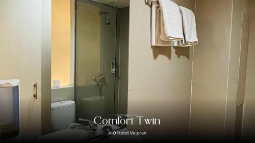 a bathroom with a toilet and a glass shower at Vio Veteran in Bandung