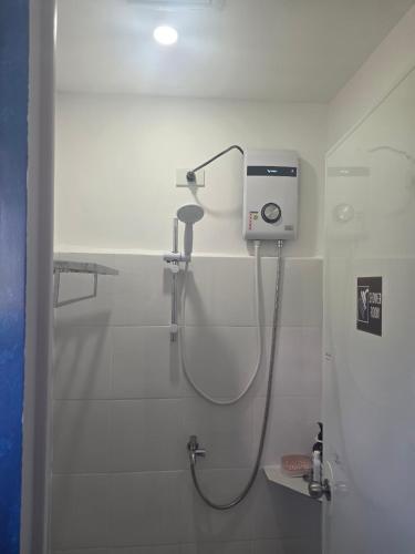 a shower in a white bathroom with a shower at 7641guesthouse in Basdiot