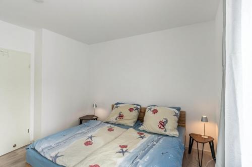 a bedroom with a bed with two pillows on it at Haus Seeluft - W1 in Butjadingen