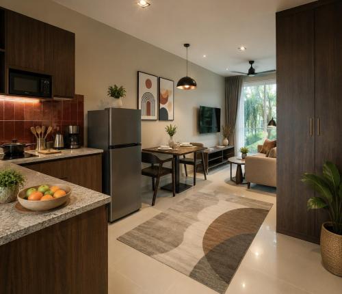 a kitchen and living room with a refrigerator and a table at Syama Mansion Kamala in Kamala Beach
