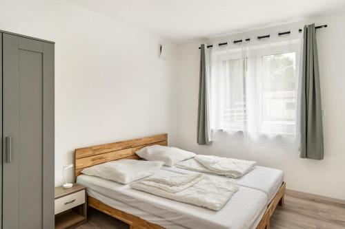 a bedroom with a bed with white sheets and a window at Haus Seeluft - W3 in Butjadingen