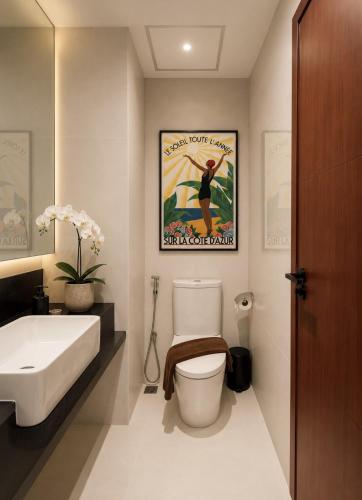 a bathroom with a toilet and a sink and a poster at Syama Mansion Kamala in Kamala Beach