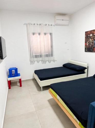 a bedroom with two beds and a tv in it at וילת צאלים in Yeroẖam