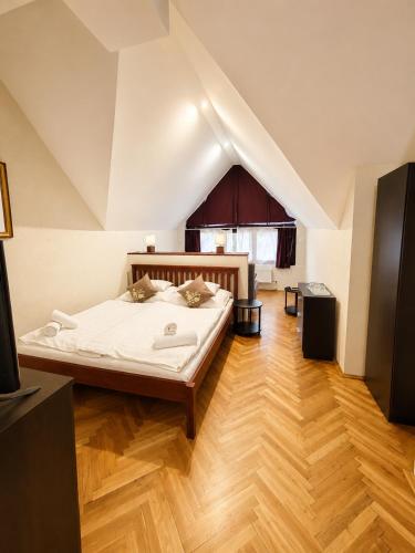 a bedroom with a large bed in a attic at Ezüstfenyő Hotel in Telkibánya