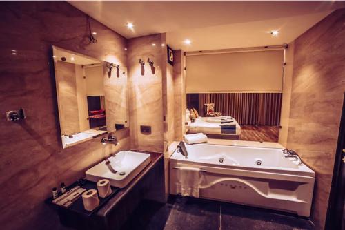 a bathroom with a tub and a sink and a bed at Hotel Vintage Zirakpur Chandigarh in Panchkula
