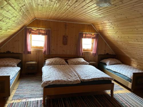 a bedroom with three beds in a attic at Jakobihütte in Sankt Margarethen bei Knittelfeld