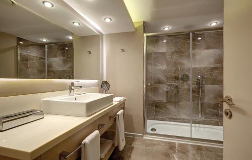 a bathroom with a sink and a shower at Heykel Suites Otel in Konak
