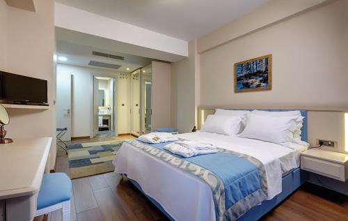 a bedroom with a large bed with towels on it at Heykel Suites Otel in Konak