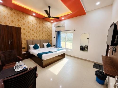 a hotel room with a bed and a television at Hotel RL Ramayansh - 300 mtr From Ram Mandir Ayodhya in Ayodhya