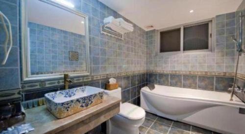 a bathroom with a tub and a toilet and a sink at Parkside Hostel in Guilin