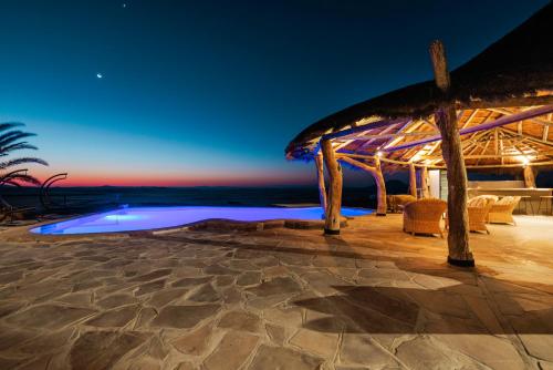 a villa with a pool at night at Rostock Ritz Desert Lodge in Cha-re