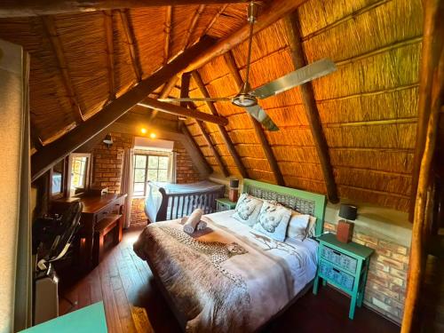 a bedroom with a bed in a wooden room at Indlovu Inn in Marloth Park