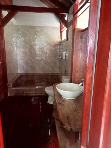 a bathroom with a sink and a toilet and a tub at Air Wontu in Moyo Island