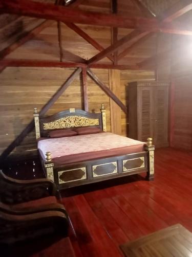 a bed in a room with a wooden floor at Air Wontu in Moyo Island