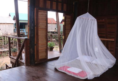 a mosquito net hanging from a door of a house at ST 63 Home Stay & Tour Kampong Khleang in Kâmpóng Khleăng