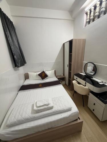 a bedroom with a bed and a desk at TUNI Hotel in Long Bình